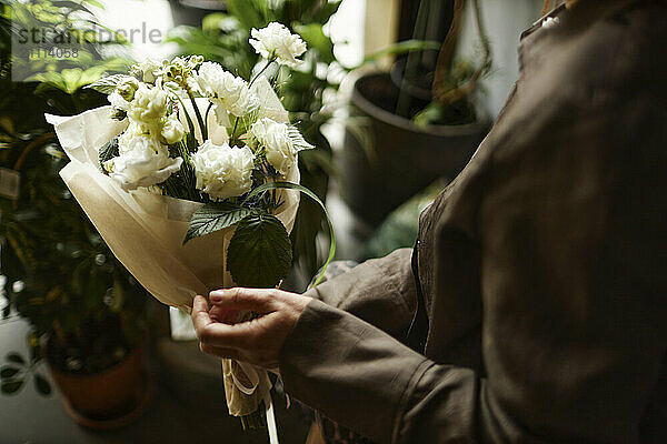 Hands of woman holding bouquet of flowers