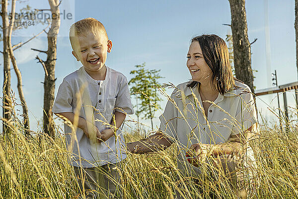 Mom and son communicate and laugh in a clearing in a city park.