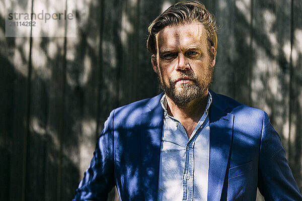 Blond hair businessman wearing blazer at sunny day