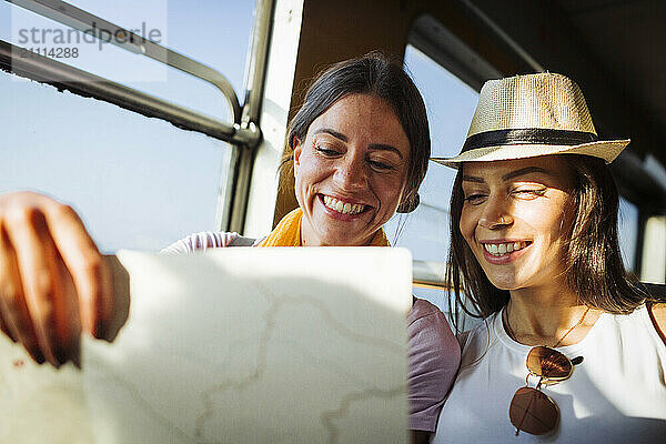 Happy friends reading map in train