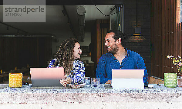 Smiling business colleagues working together in cafeteria