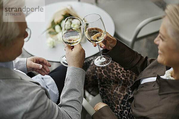 Senior couple toasting with wine at outdoor restaurant