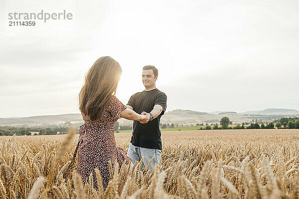 Young man spending leisure time with girlfriend in agricultural field