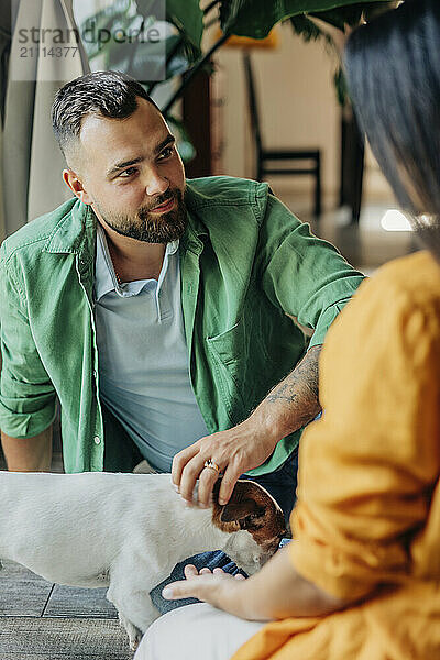 Man sitting with wife and pet dog at home