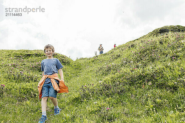 Smiling boy walking down from hill