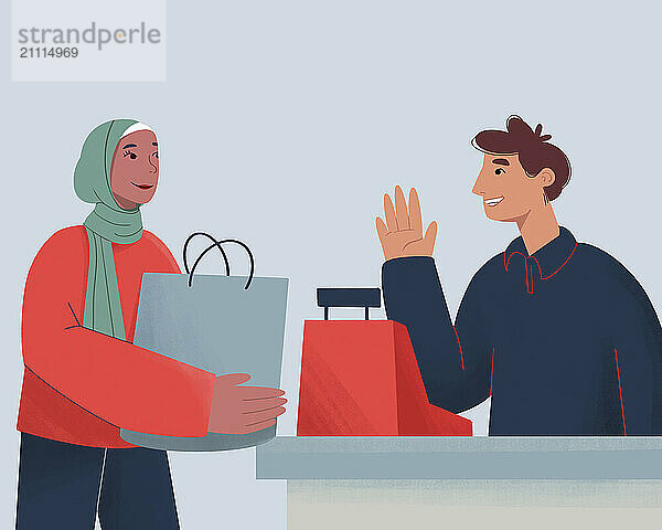 Smiling woman in a hijab handing over shopping bags to a cheerful male cashier at a checkout counter.