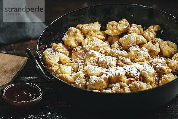 Kaiserschmarrn in einer Pfanne mit Zucker bestreut  Marmelade  dunkler Hintergrund