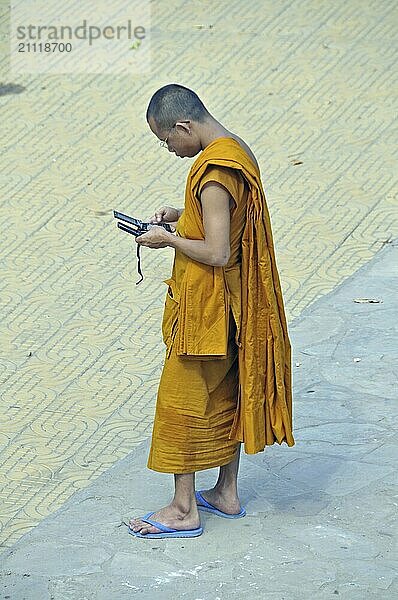 Mönch mit zwei Handys  Phnom Penh  Kambodscha  Asien