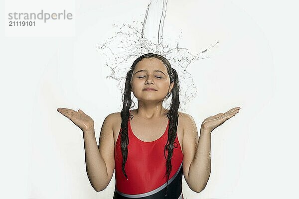 Happy Teenager Mädchen im Badeanzug fangen Wasserstrahl und Spritzer fallen auf sie von oben ihr ja geschlossen isoliertes Foto