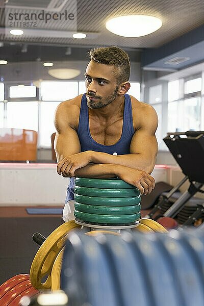 Schöner junger muskulöser Mann  der sich nach dem Training in einem Fitnessstudio ausruht