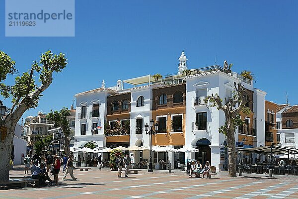 Menschen spazieren auf einem Platz mit farbenfrohen mediterranen Gebäuden und Palmen  Platz Plaza Balcon de Europa  Nerja  Provinz Málaga  Malaga  Costa del Sol  Andalusien  Spanien  Europa