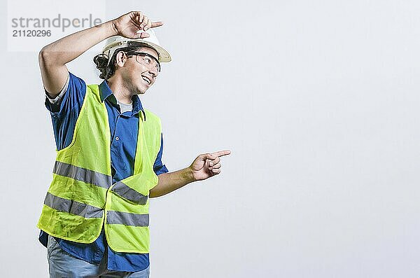 Lächelnder lateinischer Ingenieur  der mit beiden Fingern auf die Seite zeigt  isoliert. Glücklicher männlicher Bauherr  der auf eine Anzeige zeigt  isoliert