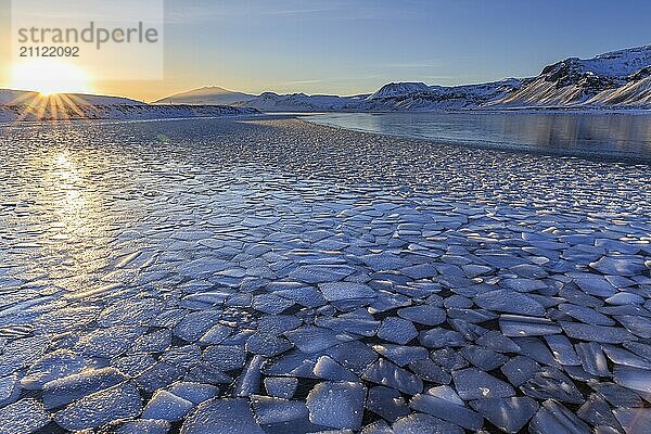 Eisschollen auf einem See vor verschneiten Bergen  Sonnenuntergang  Gegenlicht  Abendlicht  Schnee  Winter  Snaefellsnes  Vesturland  Island  Europa