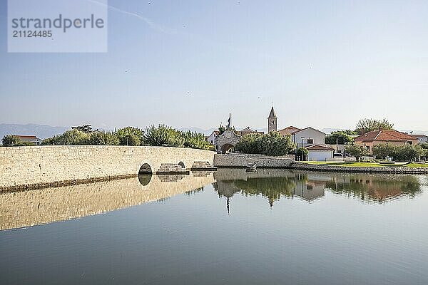 Skyline einer kleinen Mittelmeerstadt  historisches Stadtzentrum mit massiven Stadtmauern auf einer Insel in einer Bucht oder Lagune. Morgenstimmung in Nin  Zadar  Dalmatien  Kroatien  Adria  Europa