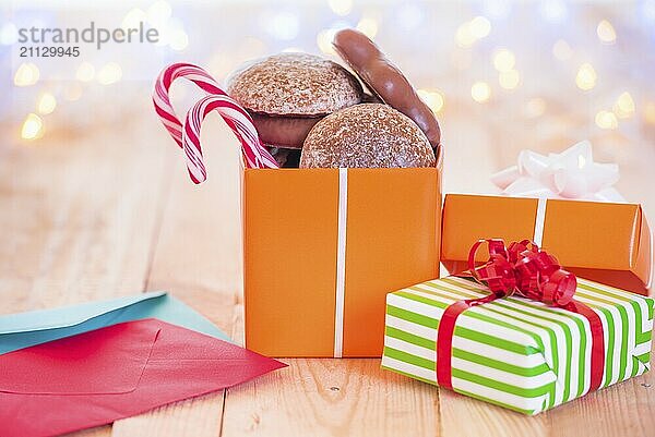 Jolly Bild mit eingepackten Geschenke  bunte Umschläge  auf einem Holztisch mit Weihnachten Bokeh Lichter im Hintergrund