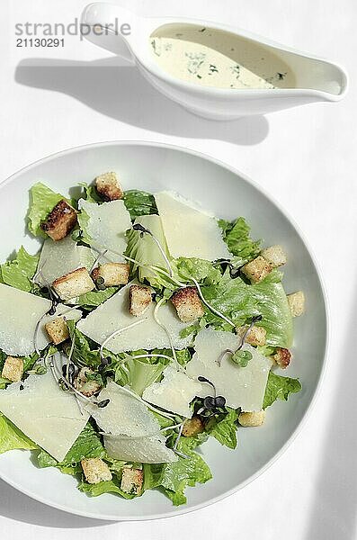 Cäsar Salat mit Parmesankäse und Croutons auf weißem Tisch