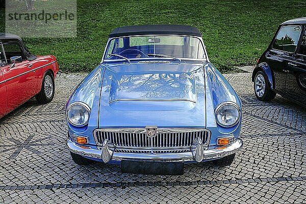 Lissabon  Portugal  20. Januar 2024: Ein klassischer himmelblauer MGC Roadster mit verchromten Details  geparkt auf einem Kopfsteinpflasterweg in der Nähe eines grünen Parks  Europa