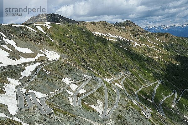 Stilfserjoch  Vinchgau  Südtirol  Italien  Stilfser Joch Passstraße  der Aufstieg über die engen Kurven  die engen Kehrer ist ein beliebtes Ziel für Radsportler  Motorradfahrer und Autofahrer  hinten schneebedeckte Berglandschaft der Schweizer Alpen  Europa