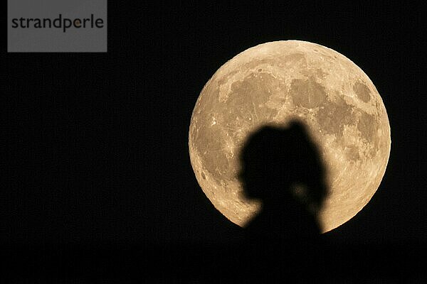 Die Silhouette einer Frau zeichnet sich vor dem aufgegangenen Vollmond ab. Am 17. und am 18. September 2024 strahlt jeweils ein Supermond vom Himmel. Nur knapp 357.500 Kilometer ist der Vollmond in der Nacht vom 17. auf den 18. September 2024 von der Erde entfernt.  Frankfurt  Hessen  Deutschland  Europa