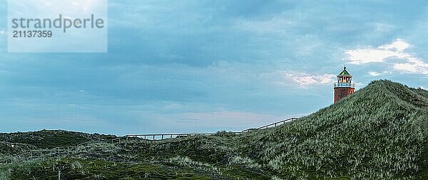 Panorama Landschaft auf der Insel Sylt in der Nordsee  Deutschland. Schöne Naturlandschaft mit Marramgrashügeln und einem Leuchtturm auf der Nordseeinsel