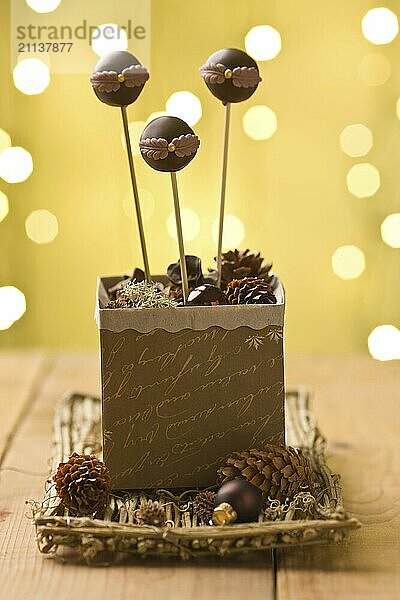 Garnierte Schokoladen Cake Pops  die in Weihnachtsdekoration stecken. Sehr geringe Schärfentiefe und Weihnachtsbeleuchtung im Hintergrund