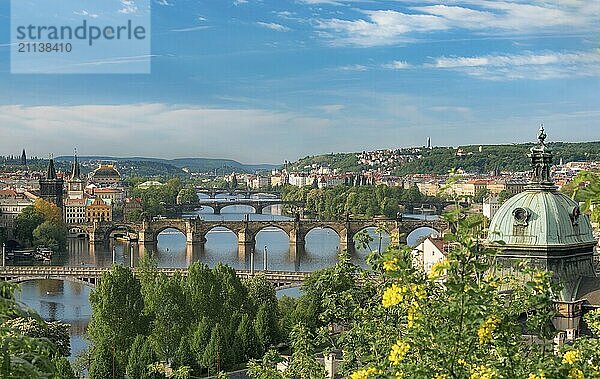 Prager Stadtbild mit der Moldau  die von vielen schönen Brücken und alten Gebäuden überquert wird  umgeben von grünen Wäldern  in der Tschechischen Republik