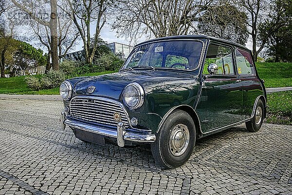 Lissabon  Portugal  20. Januar 2024: Ein klassischer grüner Mark I Mini oder Austin Mini Super Deluxe mit verchromten Details  geparkt auf einer Kopfsteinpflasterstraße in der Nähe eines grünen Parks  Europa