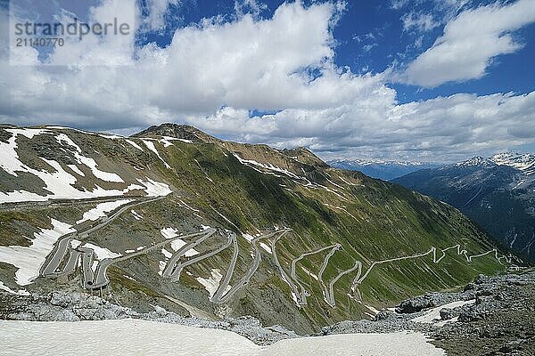 Stilfserjoch  Vinchgau  Südtirol  Italien  Stilfser Joch Passstraße  der Aufstieg über die engen Kurven  die engen Kehrer ist ein beliebtes Ziel für Radsportler  Motorradfahrer und Autofahrer  hinten schneebedeckte Berglandschaft der Schweizer Alpen  Europa