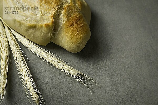 Schönes Sauerteigbrot auf grauem Hintergrund mit getrockneter Weizenblüte