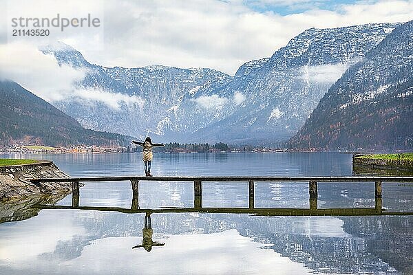 Urlaubsziele Thema Bild einer Frau mit offenen Armen genießen die schöne Hallstatter See und die Gipfel des Dachstein Gebirges  in Hallstatt  Österreich  Europa