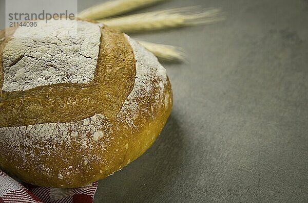 Schönes Sauerteigbrot auf grauem Hintergrund mit getrockneter Weizenblüte