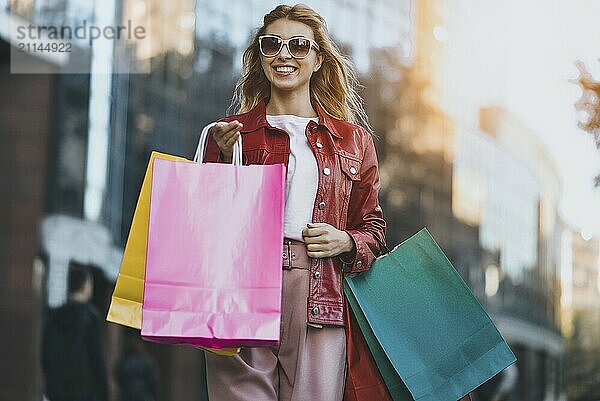 Shopping Frau zu Fuß außerhalb auf der Straße mit Einkaufstaschen. Shopper lächelnd glücklich zu Fuß die Straße nach dem Einkaufen