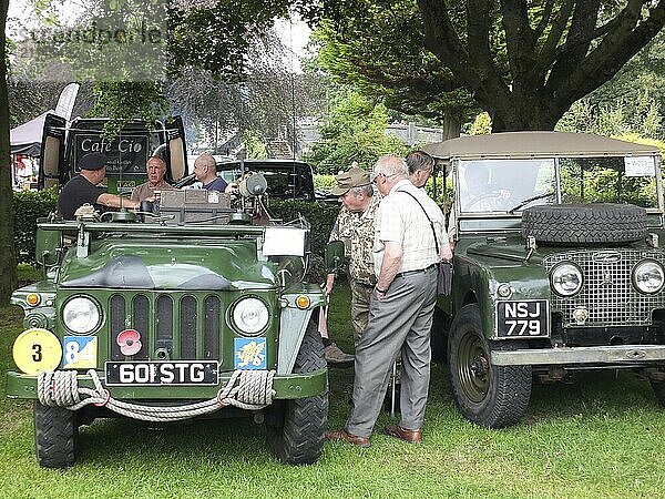 Hebden bridge  west yorkshire  vereinigtes königreich  4. august 2019: männer unterhalten sich um alte militärfahrzeuge im öffentlichen park beim hebden bridge annual vintage weekend