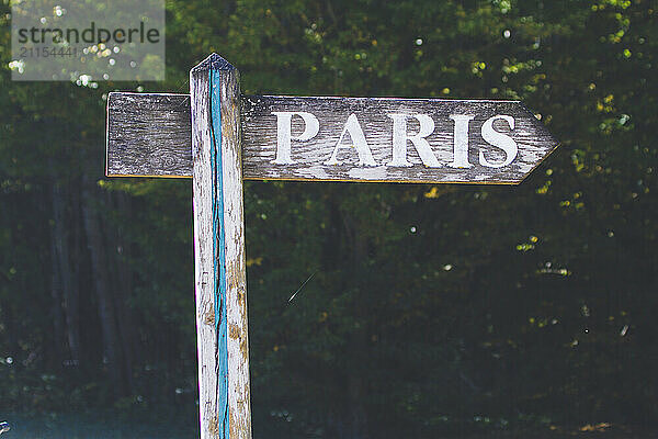 Old wooden sign pointing to Paris