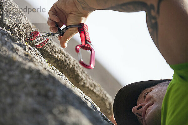 Rock climber placing cam while climbing