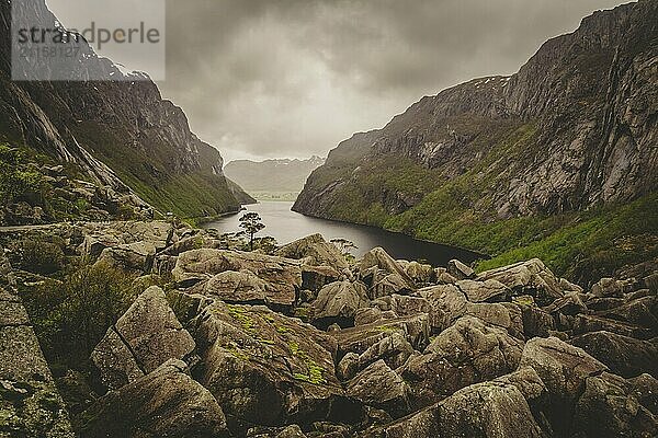 Beautiful fjord view in Norway with rock boulders and valley on a clouded day