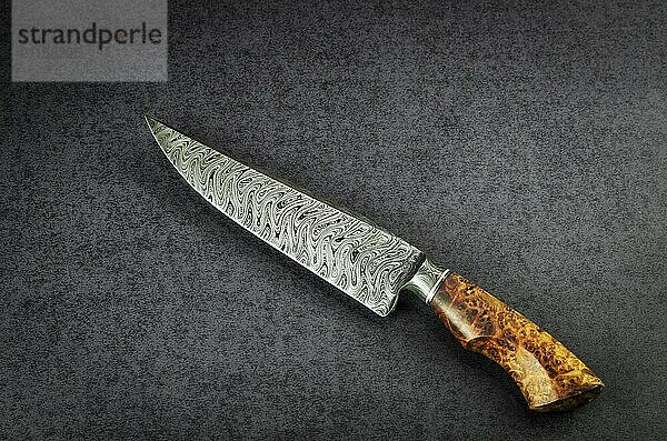 Beautiful luxurious utility knife in Texas Wind damask pattern with noble wood handle on dark background