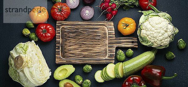 Frische verschiedene Gemüse  geschnittene Zucchini  hölzerne Schneidebrett und Messer auf rustikalen dunklen Hintergrund Draufsicht. Kochen vegetarische Mahlzeit aus gesunden Zutaten  Diät Lebensmittel und Ernährung Konzept  Lebensmittel Fotografie