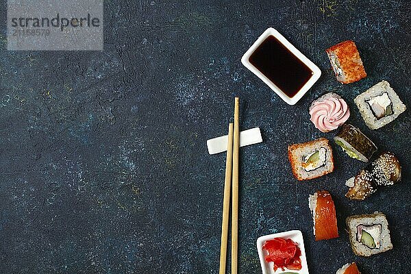 Food  Sushi roll set with chopstick and soy sauce on blue background. Copy space  top view