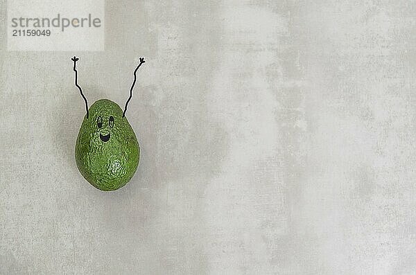 Great concept of healthy eating  avocado with happy face and arms upwards in gray background