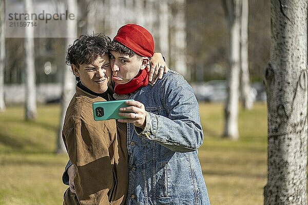 Young gay couple making funny faces taking selfies