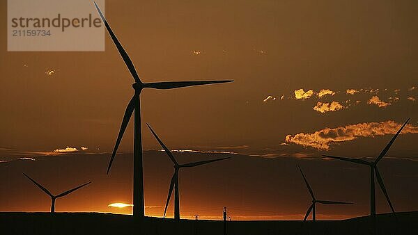 Schöner Sonnenaufgang Morgendämmerung Landschaft mit Windmühlen oder Windkraftanlage auf Windpark in Rotation zu erzeugen Strom Energie