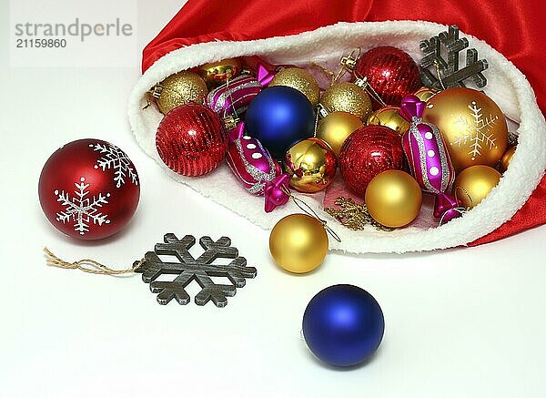 Bright christmas balls  toys in red bag on white background