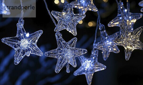 Clear star-shaped lights emitting a soft glow  creating a festive and warm atmosphere against a dark background with bokeh effect AI generated