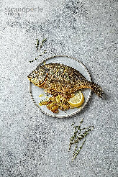 Food  Food  Grilled sea bream or dorada on gray plate. Gray background