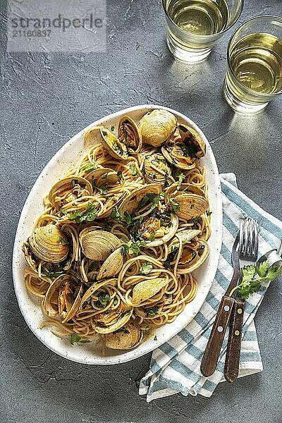 Food  Food  Seafood Pasta. ITALIAN SPAGHETTI ALLE VONGOLE. Clams spaghetti on white plate with white wine  gray background. Top view