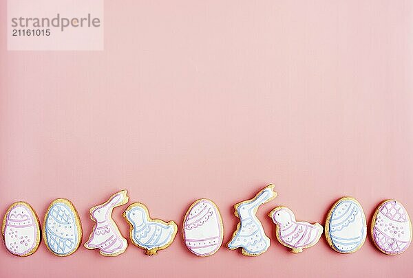 Easter frosted cookies in shape of egg  rabbit and chicken on pink background. Flat lay with copy space