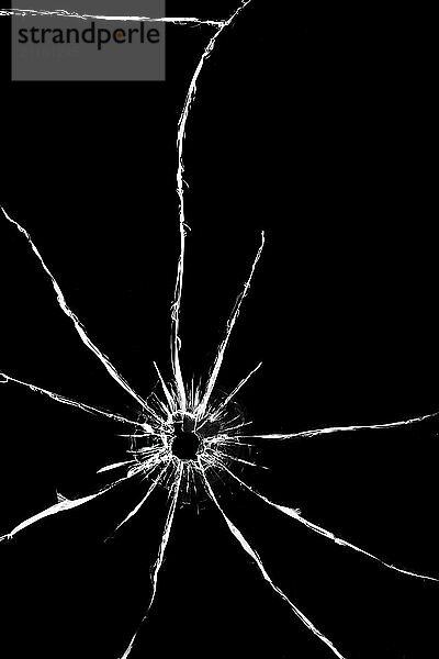 Hole from a shot with a weapon in the glass. Cracks on the back of the car. Texture on a black background  the effect of broken windshield