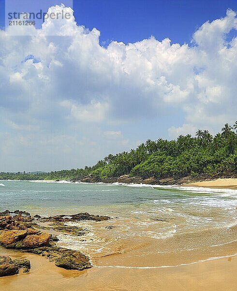 Beautiful landscape with sea waves on tropical beach with stones and rocks