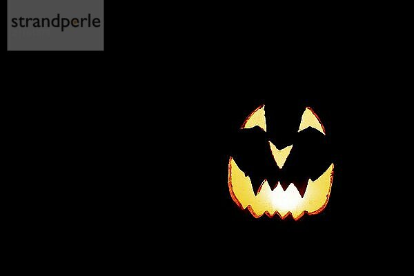 Leuchtendes Kürbisgesicht  Halloween  vor schwarzem Hintergrund